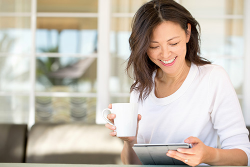 Woman reading book about hormones and aging by Suzanne Somers