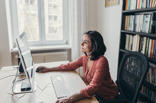 A Woman On Her Computer Finding Out About The Symptoms And Causes Of PMS