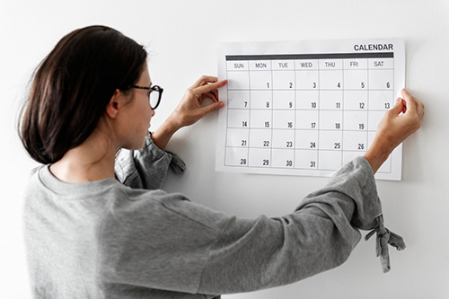 A woman looks at a calendar to track her missing period