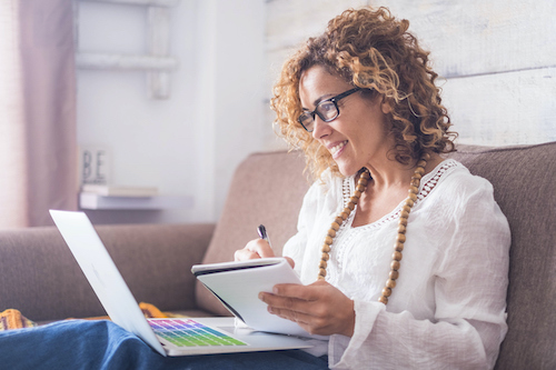 A woman taking notes about symptoms and natural treatments for estrogen dominance