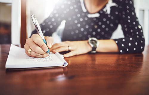 A woman taking notes on the effects of inflammation 