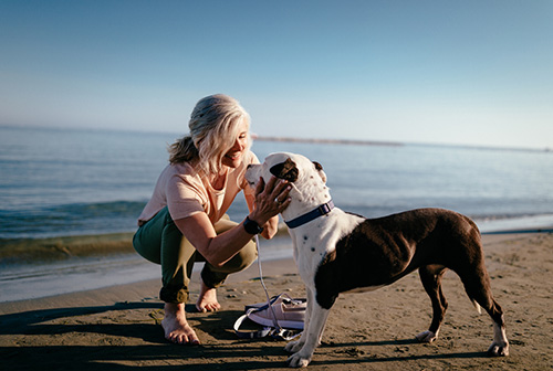 A woman with her dog taking steps to reduce inflammation and joint pain