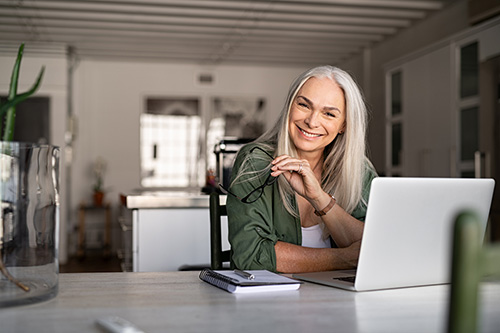 Woman at her computer reading directions for the best place to put estrogen patch