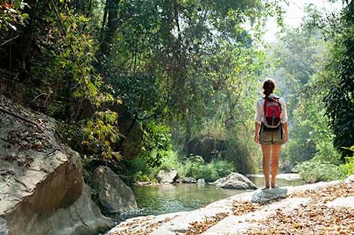 A woman concerned about ticks and risk for lyme disease as she goes out for a hike