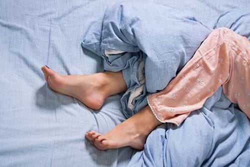 A woman with restless leg syndrome can't get to sleep