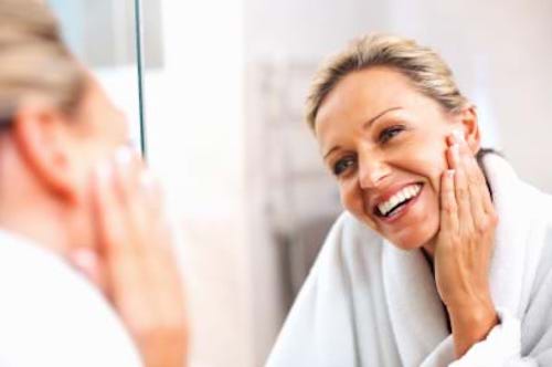 Woman looking at her skin in the mirror