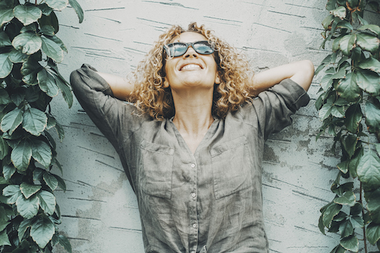 Woman leaning against a wall after finding relief from hot flashes