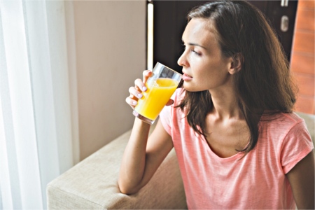 woman sitting on couch drinking digestive drink