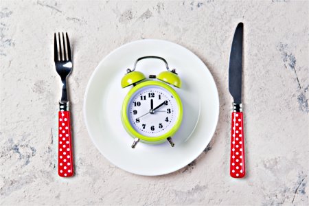 An alarm clock on a plate in a table setting 