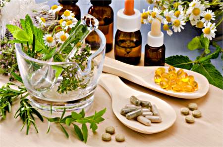 Various herbal remedies in plant form, along with pill and liquid form. Collection of herbal remedies and supplements for health.