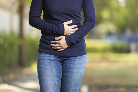 woman holding her stomach in pain