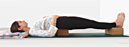 Supported Bridge Pose using two yoga blocks and one blanket