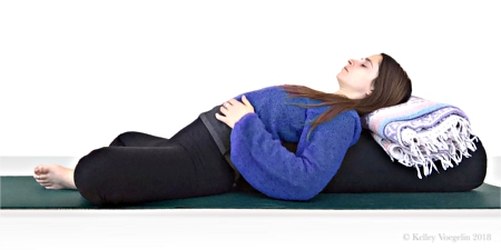 Woman doing Reclining Bound Angle yoga pose