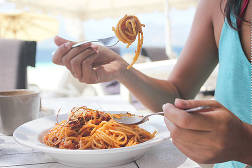woman eating a bowl of spaghetti