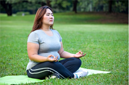 woman practicing yoga in park