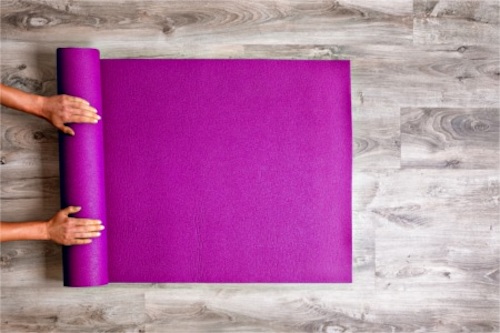 A woman unrolling a yoga mat