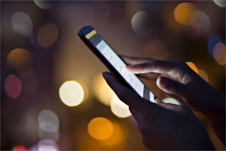 Woman using cell phone at night