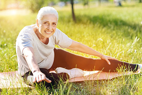 woman stretching outside in park after workout