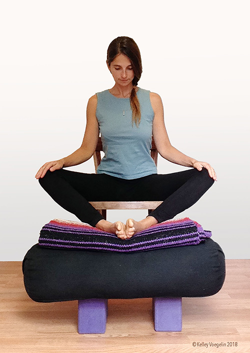 woman doing bound angle yoga pose modification in chair