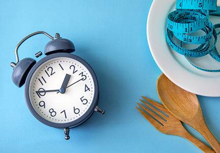 clock next to plate and utensils