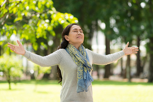 A woman practicing deep breathing to reduce her high blood pressure