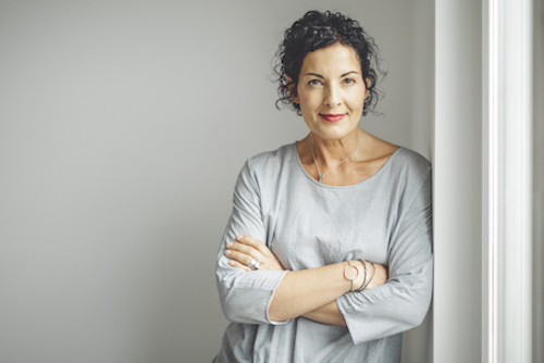 Woman Standing Against Wall Considering The Risks Of Using HRT For Osteoporosis