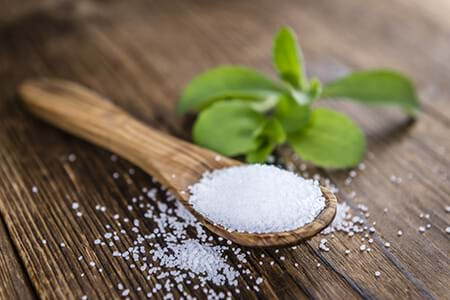 stevia plant and sweetener on wood