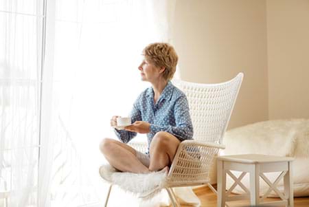 Woman drinking tea looking out window. woman drinking tea looking out window