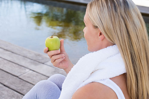 woman eating a green apple 