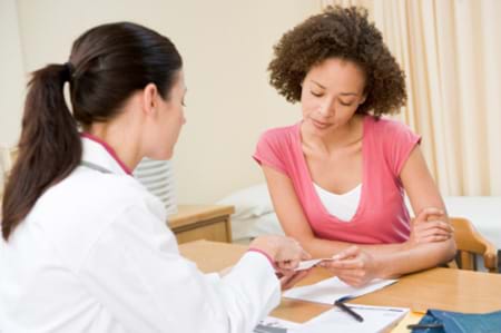 A woman going over her test results with her doctor. woman going over her test results with her doctor