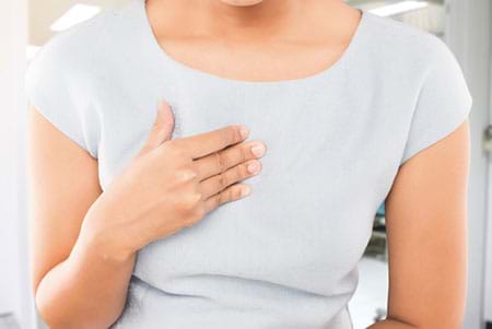 woman holding chest with acid reflux