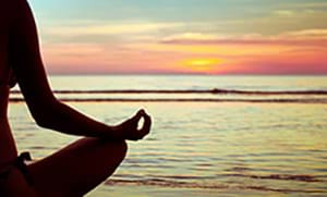 woman meditating on beach