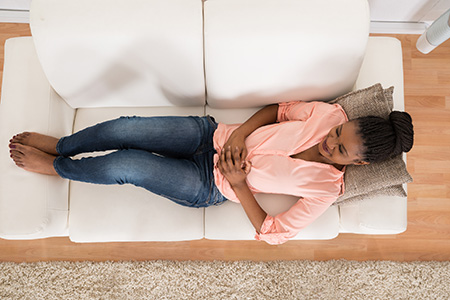 Woman on couch with digestive issues