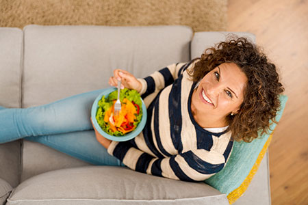 woman eating a salad as part of a healthy diet