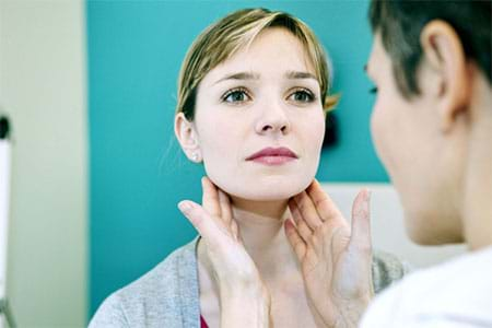 a doctor examining a woman’s lymph nodes