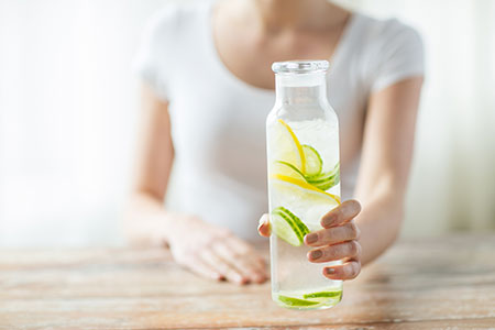 Woman storing water in glass container