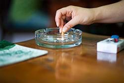 woman’s hand putting out cigarette