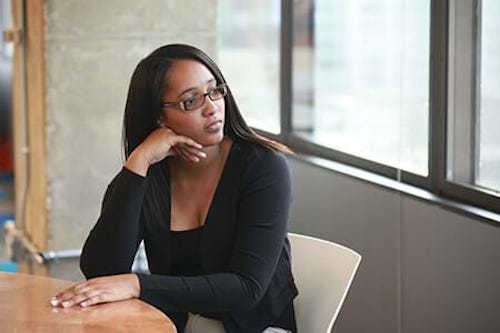 Woman Sitting At Table Staring Out Window