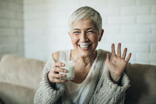 Woman drinking milk to get calcium and Vitamin D for her bones. 