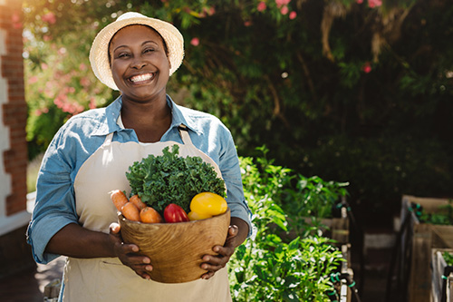 Woman gardening and gathering fresh vegetables for improved nutrition