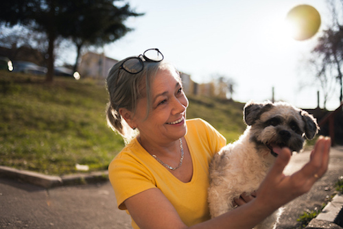 Woman with osteoporosis playing with her dog. 