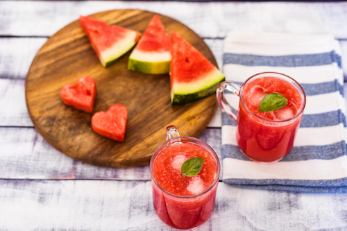 Heart Shaped Watermelon Pieces On Wood Plate With Juice